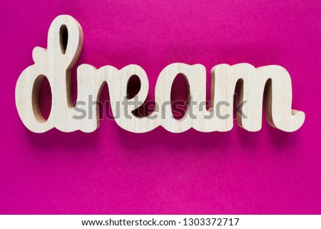 Wooden word Dream on purple background. Summer, vacation, holidays concept. 