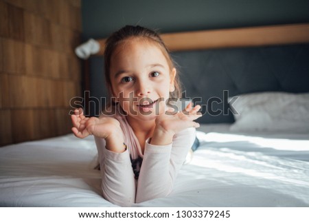 little girl lying on the bed smile