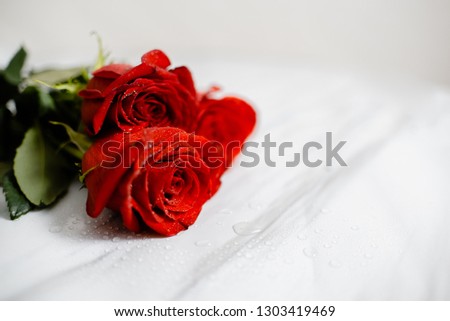  Bouquet of Beautiful red roses with water drops macro picture in the morning warm sunlight. Horizontal Close up view with copyspace.  Marble table