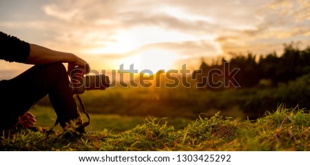 Nature photographer , Photographer are sitting look the sunset 