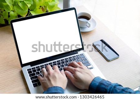 mockup image computer hand typing with blank screen for text,man using laptop contact business and searching information in workplace on desk in office.design creative work space on wooden desktop