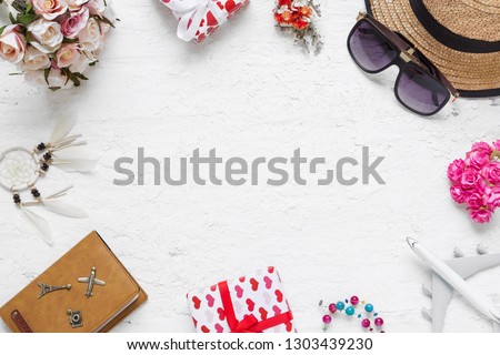 Flat lay table top view  of decorations valentine's day & summer travel holiday background concept. Overhead shot items plan to travel. Rose flowers, heart gift box, airplane model on wood background.