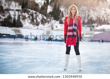Woman ice skating outdoor at ice rink stadium. Wearing in skating shoes outdoor. Healthy lifestyle and winter sport concept
