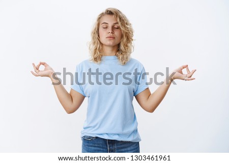Peace is vital. Portrait of calm and relaxed unbothered young woman meditating with closed eyes and focused face standing in lotus pose, search nirvana with mudra signs, practicing yoga