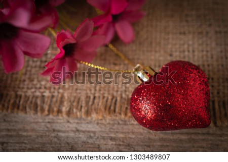 Red plastic heart placed on the Sack.There is a flower placed on the left back.