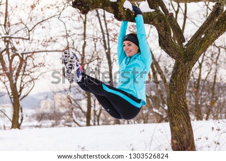 Sports and activities in winter time. Slim fit fitness woman outdoor. Athlete girl training wearing warm sporty clothes outside in cold snow weather.