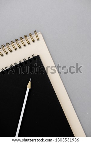 Stationary concept, Flat Lay top view Photo of notepads  on beige background with copy space.Creative flat lay photo of workspace desk with  white and black notebooks minimal style.Top view of open 