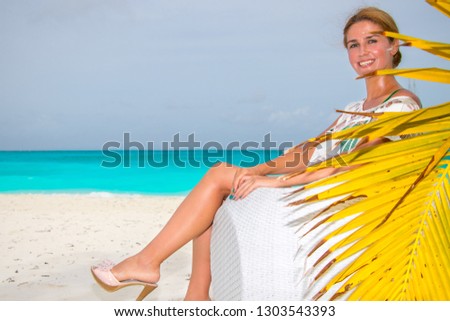 Young woman sitting on sofa at the beach