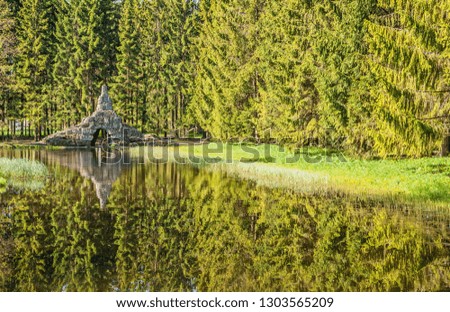 Stone grotto on the lake in the coniferous forest