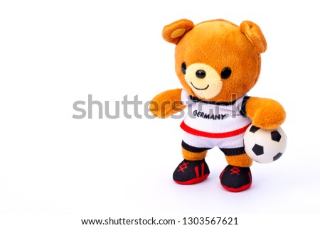 Teddy bear athlete in Germany dressed player with ball isolated on white background.