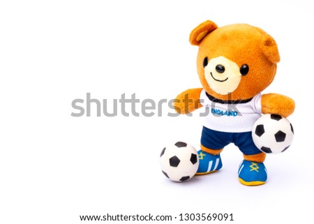 Teddy bear athlete in England dressed player with ball isolated on white background.