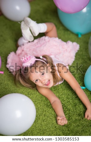 Girl child with balloons in the studio