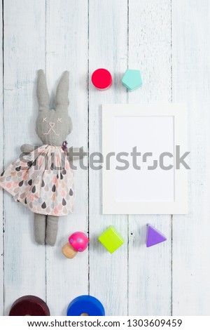 white empty picture frame illustration copy space, homemade rabbit doll, wooden background