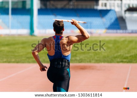 javelin throw athlete thrower running in track stadium Royalty-Free Stock Photo #1303611814