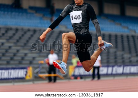 triple jump male athlete jumper in track stadium Royalty-Free Stock Photo #1303611817