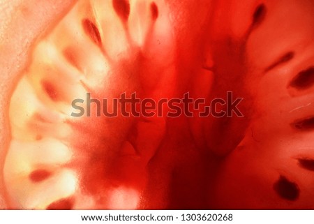 Red tomato cut in half with the texture of seeds and pulp
