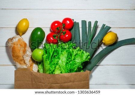 Paper bag of different health food on white wooden background. Top view.