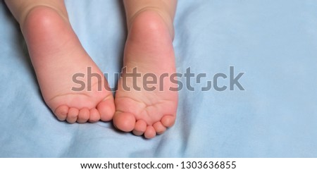 Baby's closeup little barefeet. Children's feet. Barefeet on the bed. Kid's feet in bed. Infant crawling with focus on barefeet. Heels and toes on bed. Heels and feet. Copy space.