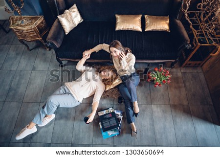 Two friends celebrate the holiday in a cozy atmosphere with wine and call friends
