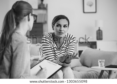 Confused young woman with social problem during psychologist meeting , black and white photo