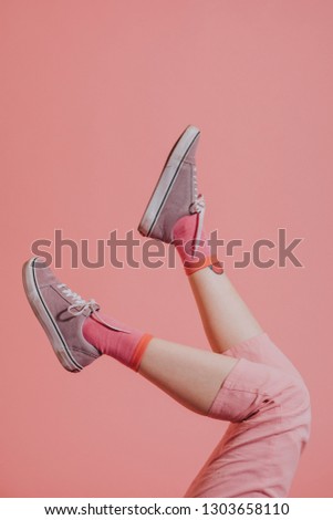 Female legs in pink pants up in the air Royalty-Free Stock Photo #1303658110
