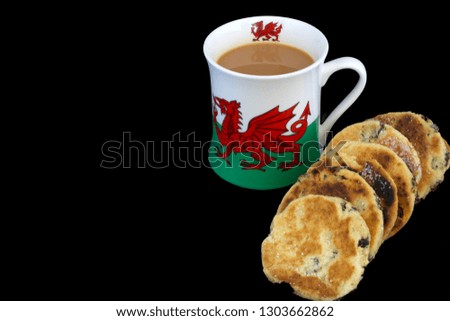Welsh Dragon flag mug with Welsh cakes on a black background. Copy space. Image.