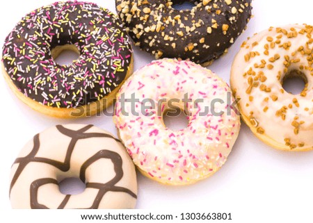 A appetizing group of white chocolate donuts,black chocolate donuts with colorful sweets and other browns