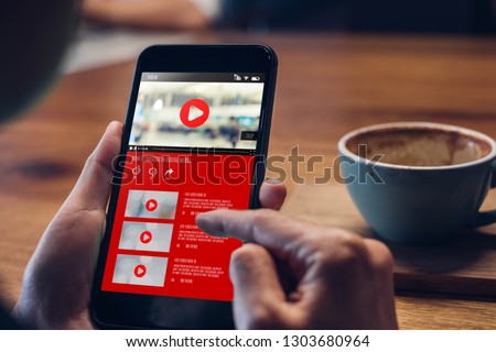 close up woman hand holding mobile watching video online with advertising on mobile on sofa at home.viral influencer media concept