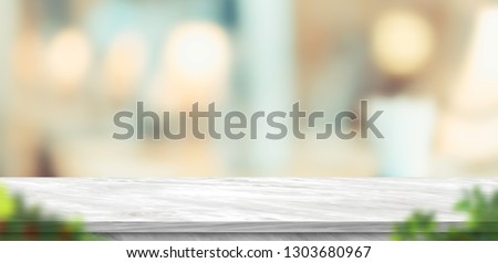 Empty grey marble table and blurred soft light table with foreground leaf in luxury restaurant with bokeh background. product display template.Business presentation Royalty-Free Stock Photo #1303680967