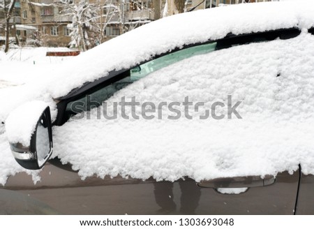 Auto covered with snow in winter .