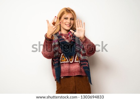 Hippie woman over white wall counting nine with fingers