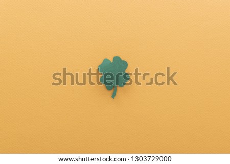 top view of shamrock isolated on orange with copy space, st patrick day concept
