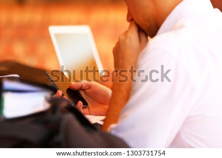 Close up of a male high school student holding a mobile cell phone texting at school. Distractions and school with social media and digital technology. Online cyber bullying concept.  Royalty-Free Stock Photo #1303731754