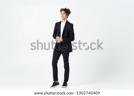 attractive man in patent leather shoes and in a classic full-length suit on a light isolated background                     