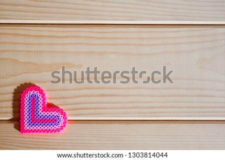 Panel of light wooden boards and a red plastic heart.