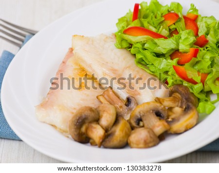 Fish fillet with mushrooms and salad