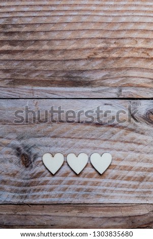 Three wooden hearts on a wooden and lace background