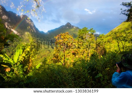 photographer traveller and rainbow natural phenomenon in forest on the mountain at Chiang dao Chiang mai Thailand .