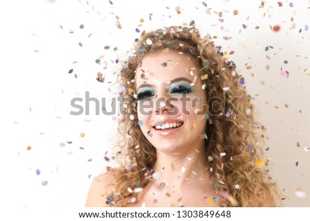 beautiful blonde woman celebrating with rain of confetti, concept of a birthday or carnival