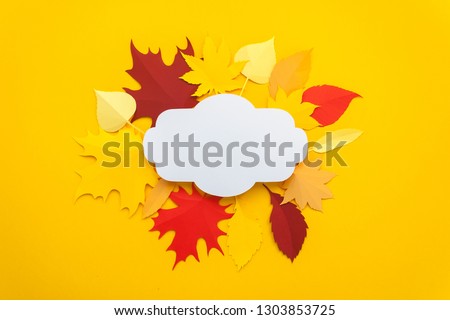 Autumn leaves cut from paper on yellow background.