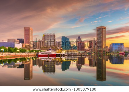 Baltimore, Maryland, USA Skyline on the Inner Harbor with dramatic skies at dusk.
