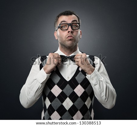 Funny nerd preparing to go out for a date isolated over dark gray textured background