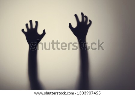 Dark silhouette of woman hands behind glass door. Concept of depression, fear, panic attacks 