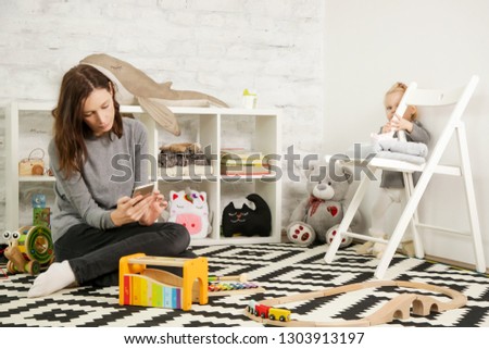 Irresponsible babysitter hanging on the phone and doesn't pay attention to the baby
 Royalty-Free Stock Photo #1303913197