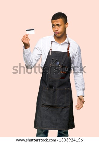 Young afro american barber man taking a credit card without money on isolated background