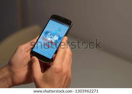 Hands holding mobile phone with Valentine's day concept on the screen.
