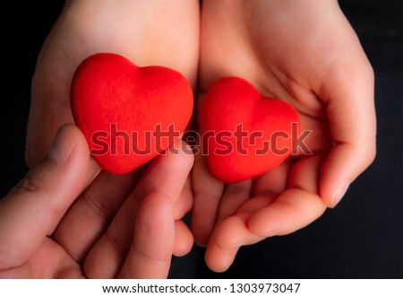 Red hearts drawing on hands of a couple holding hand in hand, lovers, symbol of love, togetherness, hands holding, love, Valentine’s Day