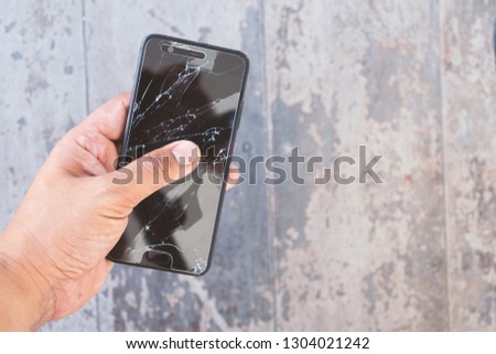 Hand holding the broken smartphone