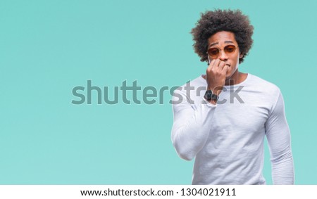 Afro american man wearing sunglasses over isolated background looking stressed and nervous with hands on mouth biting nails. Anxiety problem.