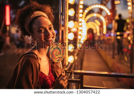 Portrait of a beautiful young woman having fun at the amusement park